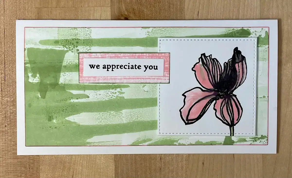 A card with a pink flower created using various inking techniques.