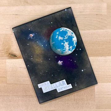 Out of this world card featuring ink blending with dark colors and a stenciled earth.