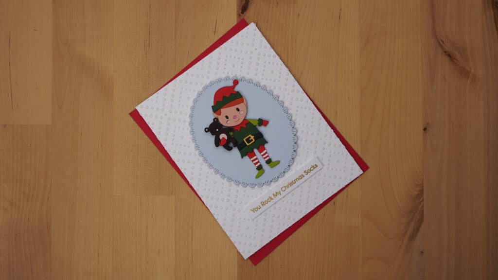 The card for Day 6 is a darling die cut elf card on a multi-media background.
