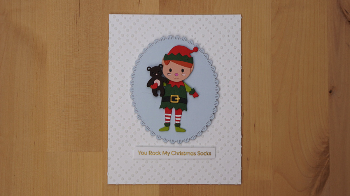 The card for Day 6 is a darling die cut elf card on a multi-media background.