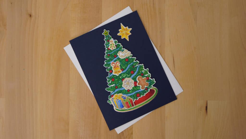 A beautifully Christmas Tree is the focal point for this lovely card colored with alcohol markers and layered stencils.