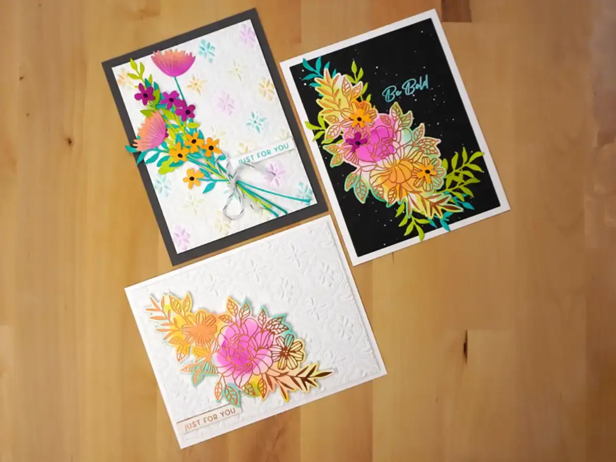 Three cards with Floral Reflections on them on a wooden table.