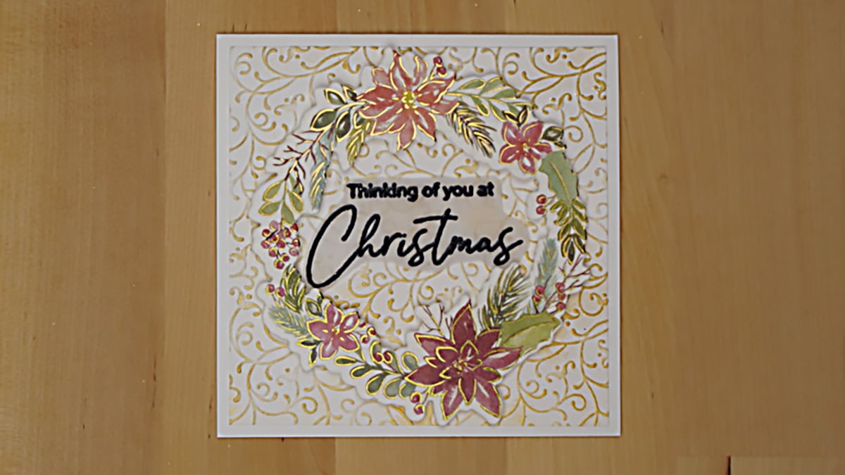 Stunning Christmas card with a poinsettia wreath focal point accented with gold.