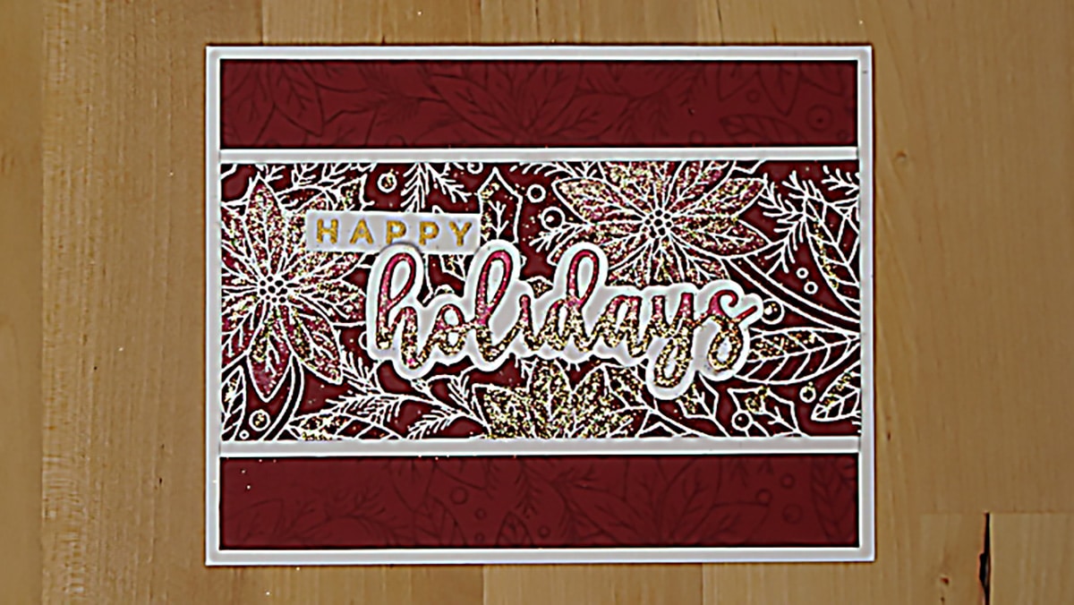 A stunning holiday card with the text "HAPPY holidays" in gold and white glitter letters on a patterned red and white background with leaf designs.