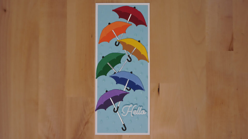 The fourth card made with products from Spellbinders' January features six umbrellas in rainbow colors with a simple sentiment saying hello.