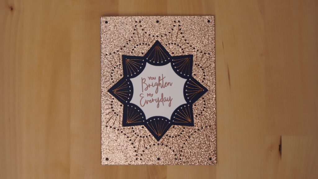 Spellbinders' January Stitched Die of the Month is used to create this glittery card to brighten someone's day.