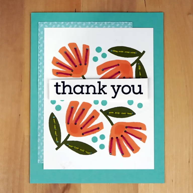 A "thank you" card with orange flowers, green leaves, and blue dots on a white background. The card, which reflects the joy of summer camp memories, has a teal border and is placed on a light wooden surface. Perfect for cardmaking enthusiasts!