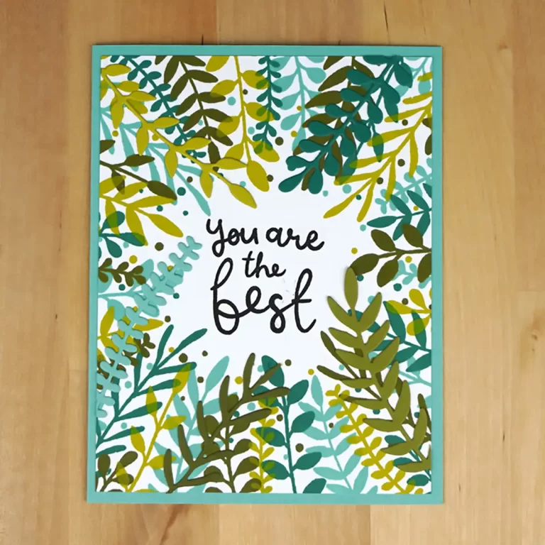 A greeting card with the text "You are the best" surrounded by various green and yellow leaves, placed on a wooden surface, perfect for showcasing your Cardmaking skills.