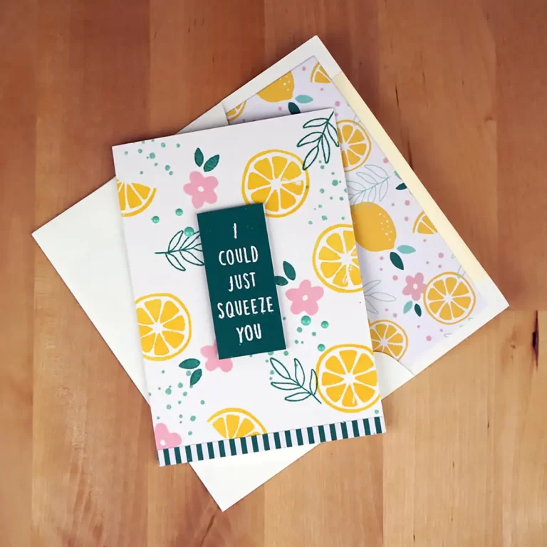 A greeting card with lemon and floral designs reads, "I could just squeeze you." Another partially visible card with similar designs is placed underneath on a wooden surface, reminiscent of creations from a Cardmaking Summer Camp.