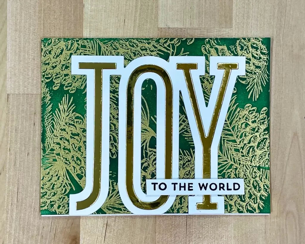 Stunning Christmas card with unique embossing used for the background and die cut "Joy" sentiment