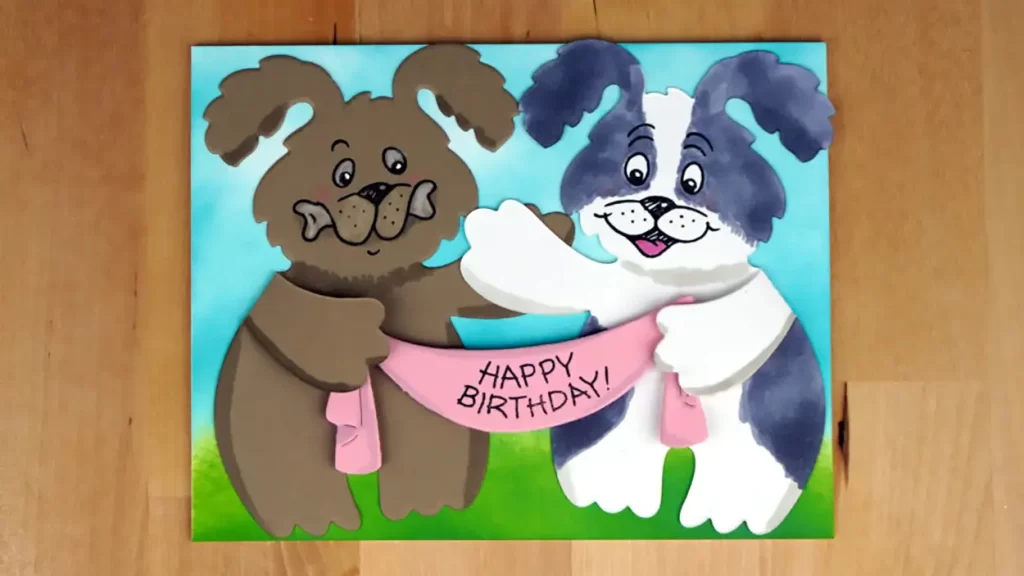 A pair of pups are the focal point for this birthday card.  They are die-cut and colored over a blended background.