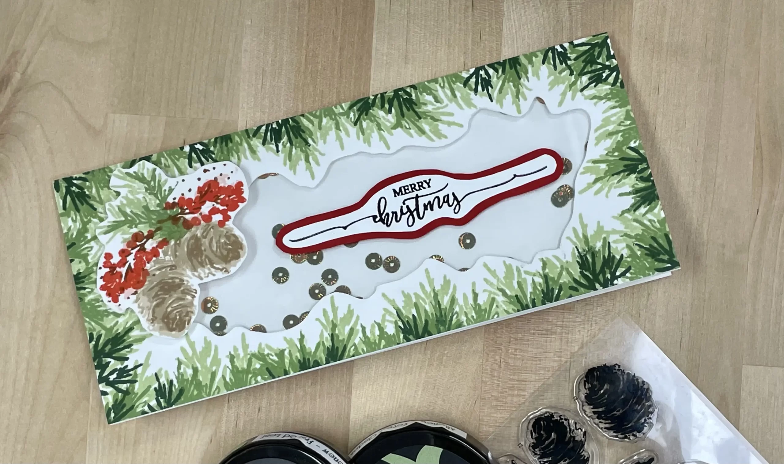 handmade shaker card decorated with pinecones and greenery.