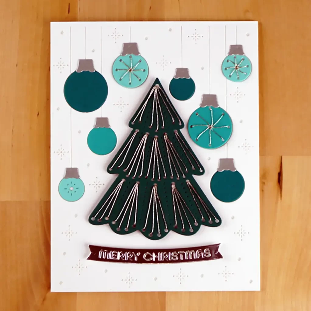 Card 4 of 4 Stunning Stitched cards created using Spellbinders October 2023 Stitching Die of the Month.  This one has a white background with a teal Christmas tree and ornaments.