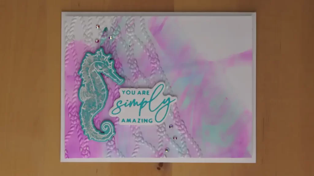 This lovely card was created with stamps, dies, sentiments, and an embossing folder from the Seahorse Kisses collection. 