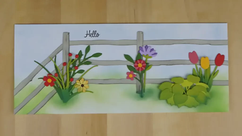 Pretty slimline  card created using products from the new Spellbinders release, Country Roads.  The card features a simple fence corner with die-cut flowers and greenery inside.