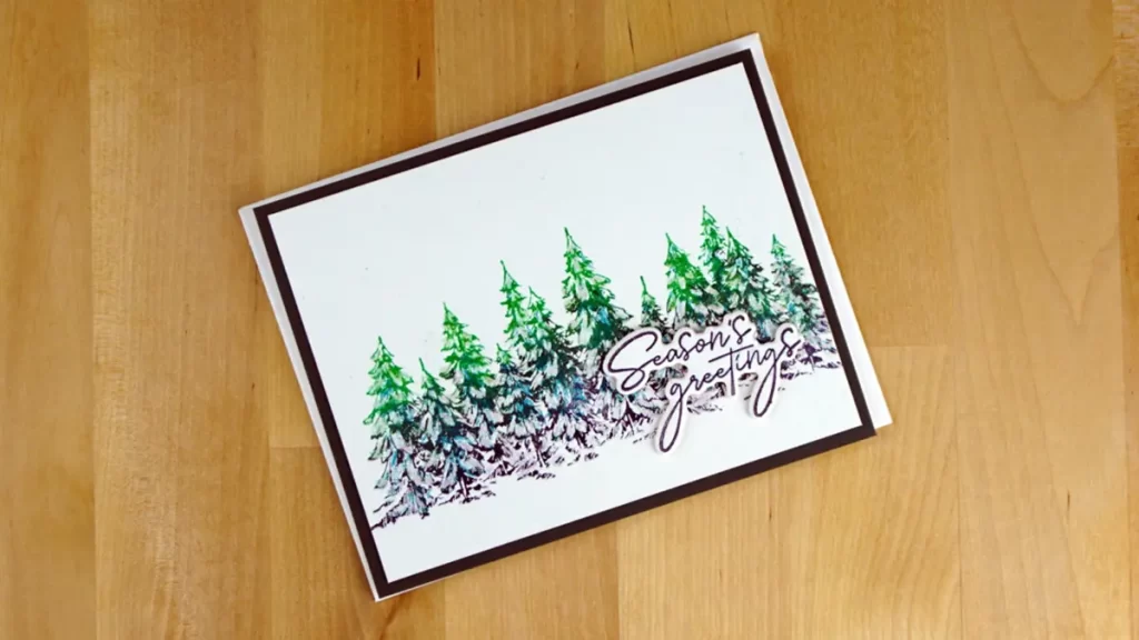 Almost clean and simple, this card features a BetterPress Evergreen forest colored in greens, teals, and black.
