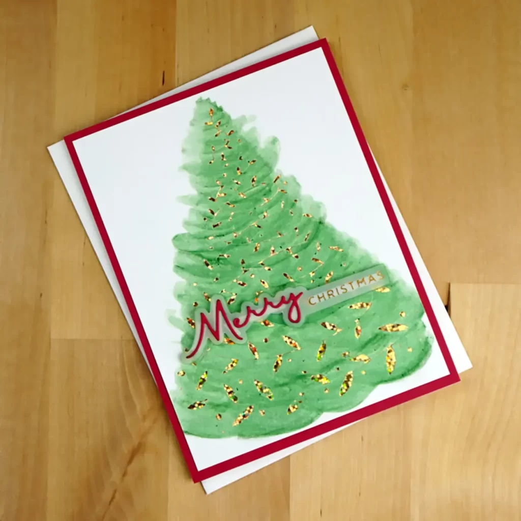 Pretty Christmas Card created with Spellbinders' Swirling Foliage hot foil plate and colored in traditional green and red with Distress Watercolor pencils.