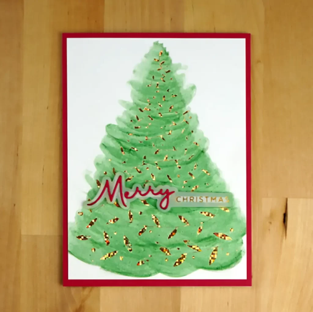 Pretty Christmas Card created with Spellbinders' Swirling Foliage hot foil plate and colored in traditional green and red with Distress Watercolor pencils.