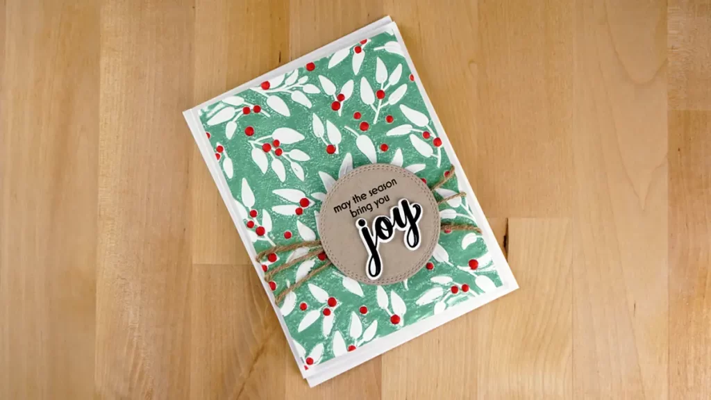 Joyfully Celebrate Kraft Joy card embossed and stenciled with Altnew's Joyful Greenery from their October 2023 release.