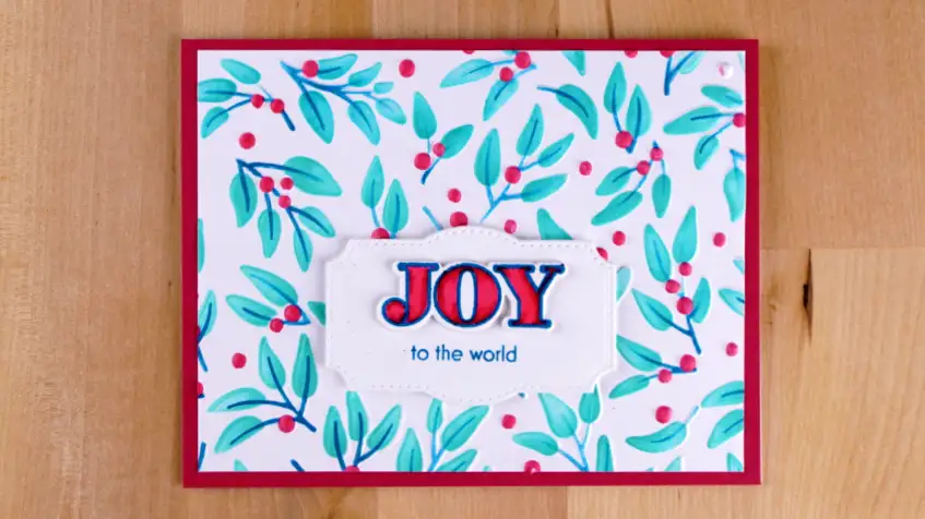 Joyfully Celebrate Joy to the World card embossed and stenciled with Altnew's Joyful Greenery from their October 2023 release.