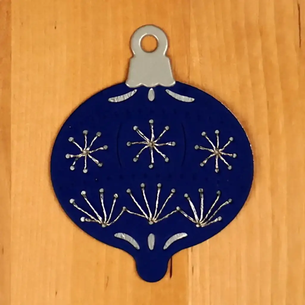 A blue ornament hanging on a wooden surface.