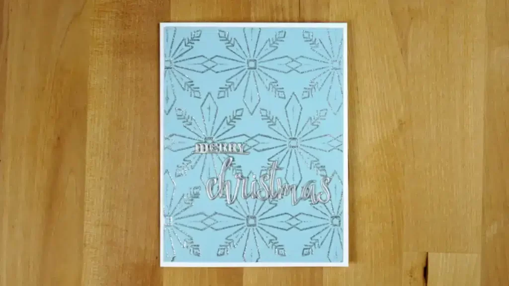 A sparkling blue card adorned with silver snowflakes.