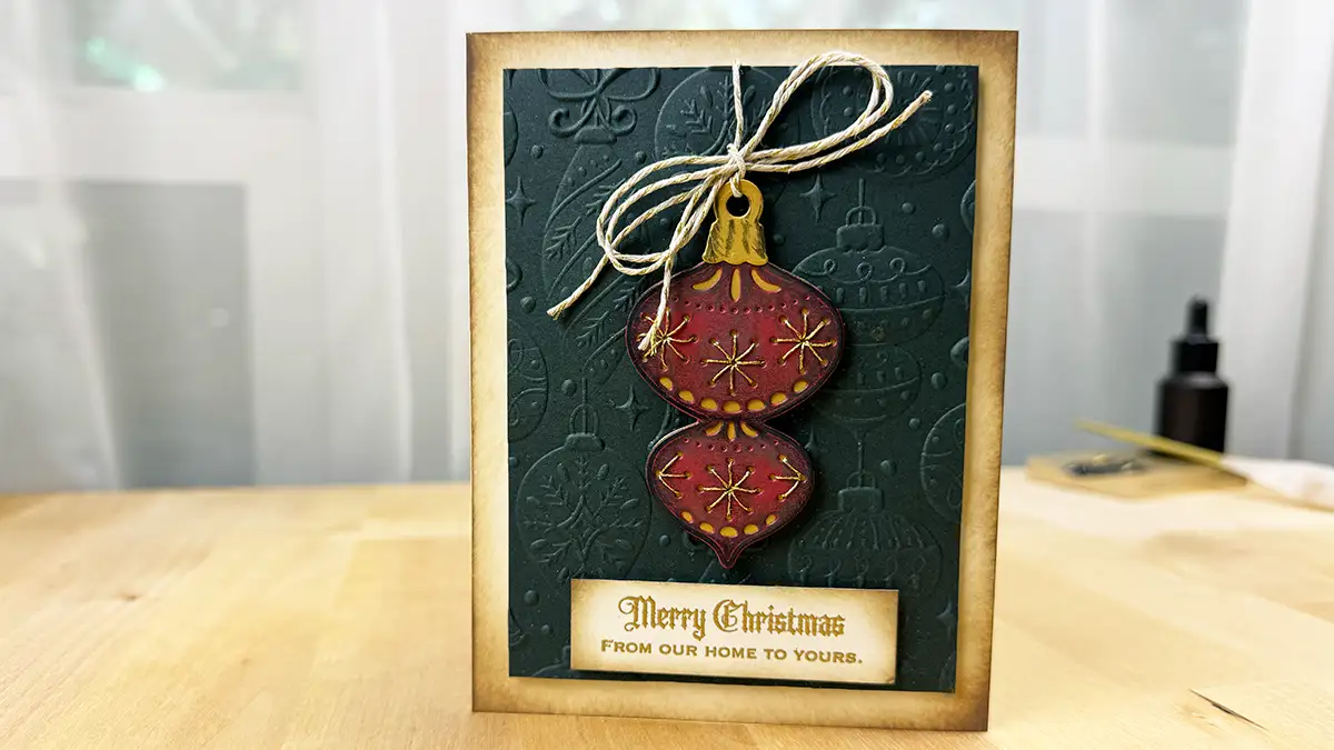 A Christmas card with a vintage ornament on it for Stitchmas Day 3.