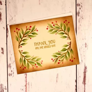 A stenciled thank you for the lovely gift card with greenery and red berries