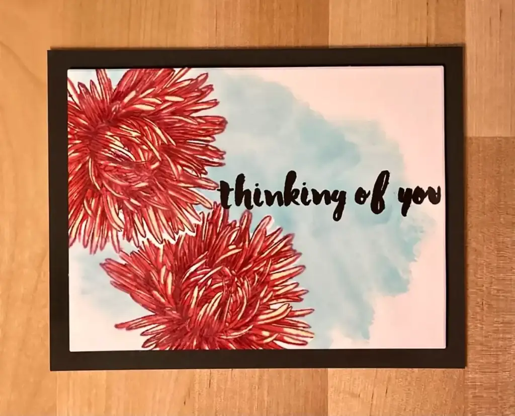 A card with red flowers and the words thinking of you, created using masking methods.