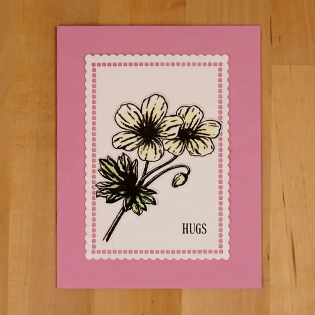 A pink card with white flowers on it.