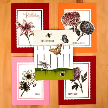 Four cards with Beautiful Blooms flowers and butterflies on a wooden table.