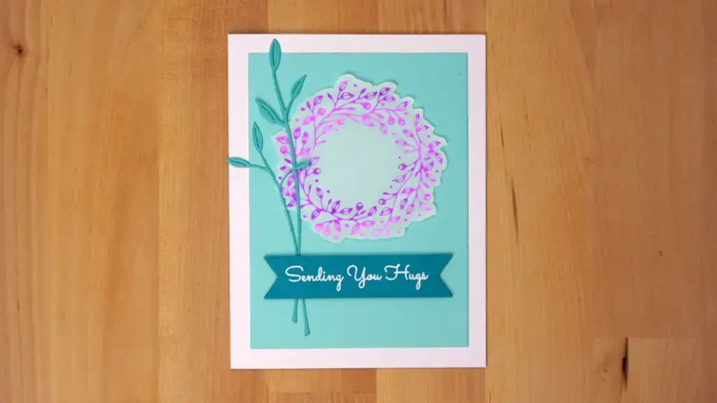 A foil-stamped card with intricate leaf dies creating a captivating circle motif.