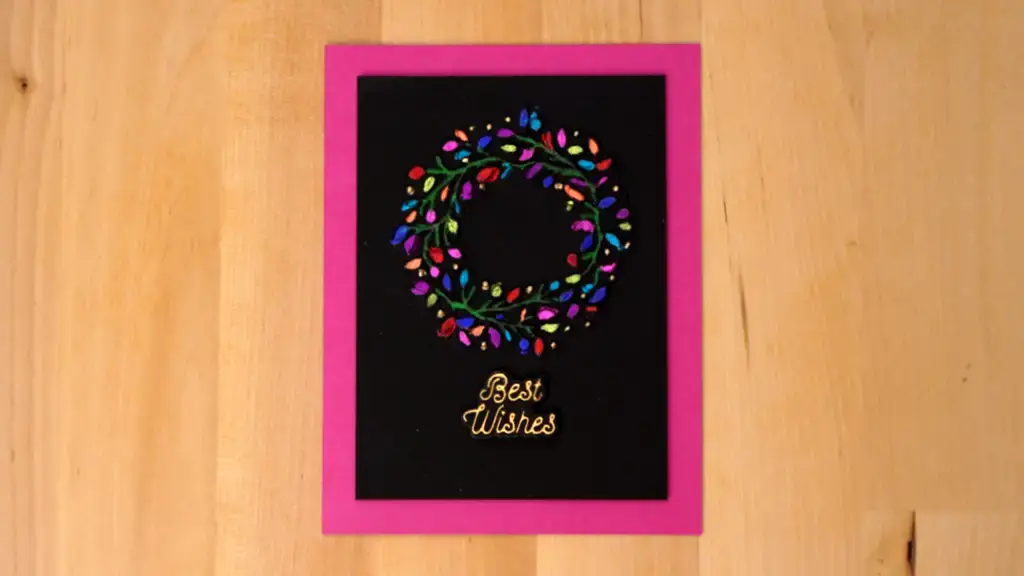 A foil-embossed card with a festive wreath of lights.