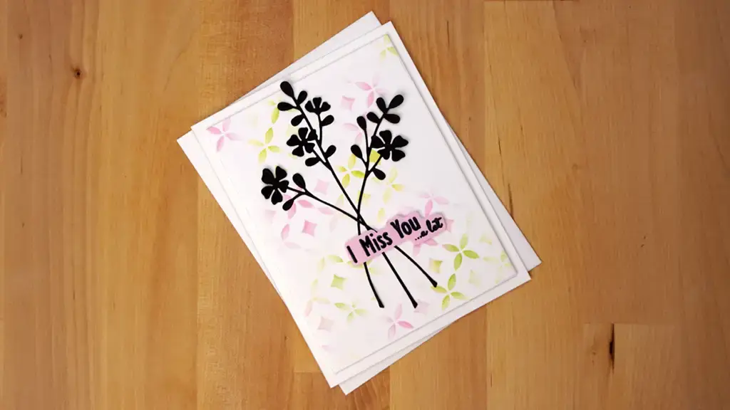 A beautifully embellished card featuring intricate floral designs created using foil and dies.