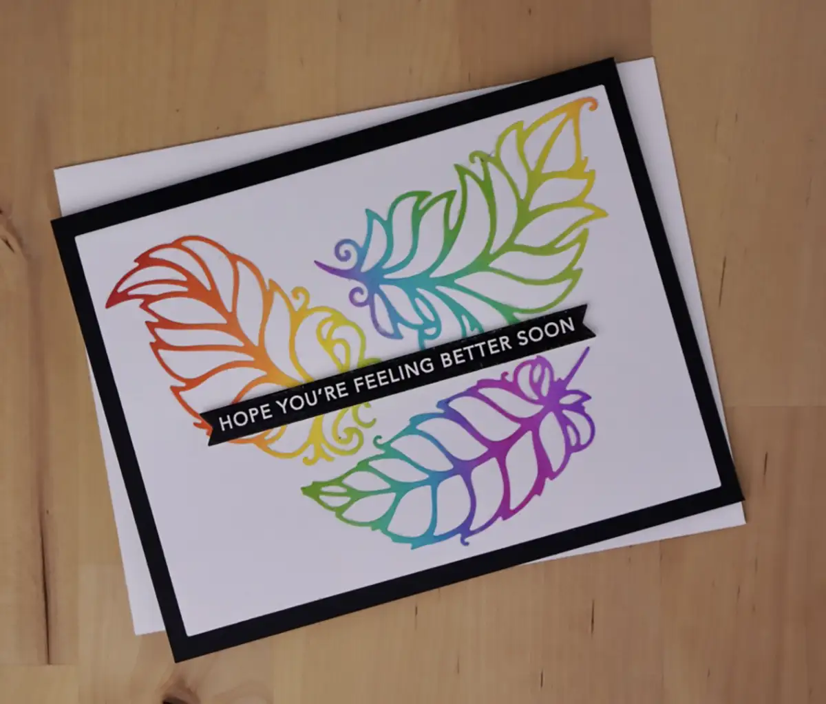 Three cards featuring colorful feathers on a single die-cut design.