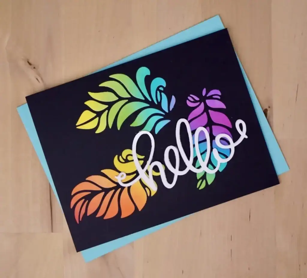 A vibrant greeting card with colorful feathers and the word hello, crafted from a single die-cut.