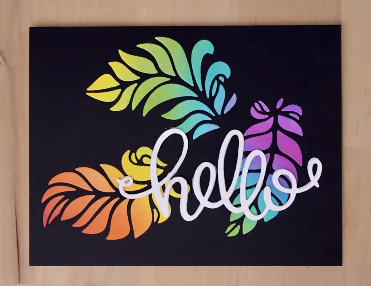 A black sign with a rainbow colored leaf design, made from 3 cards.