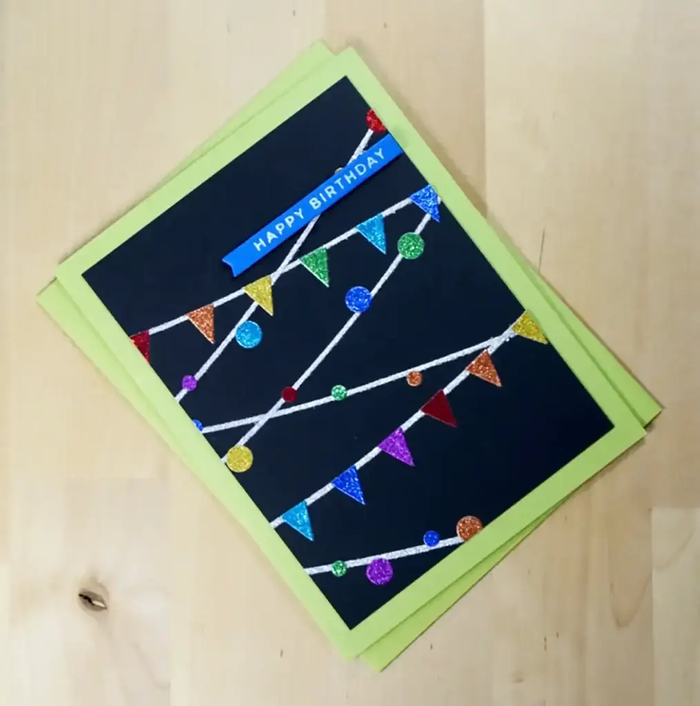 Spellbinders' New Release features a black card embellished with colorful bunting.