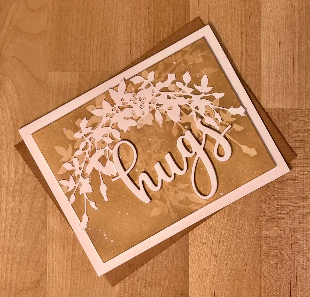 A card featuring the word hugs, created using masking methods.