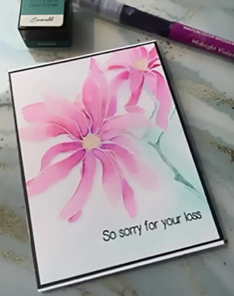 A card with pink flowers and a marker next to it, showcasing 4 ways to watercolor.