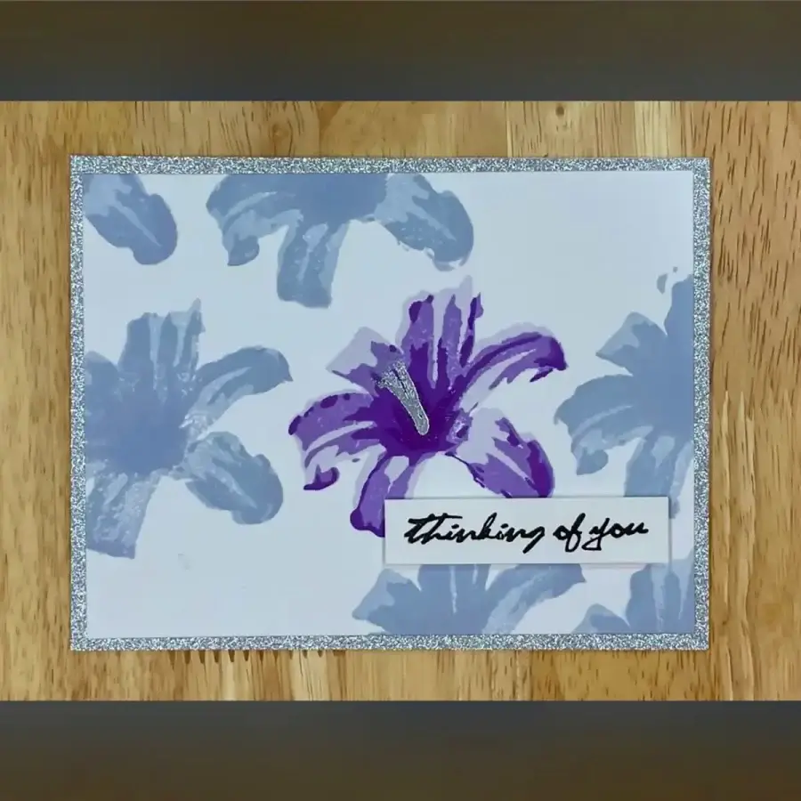 A card with layered purple flowers on it.