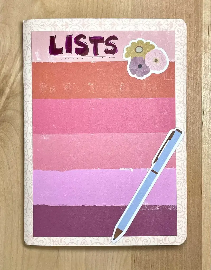 A Crafters Traveler's Notebook with a pink and purple cover, complete with a pen on top.