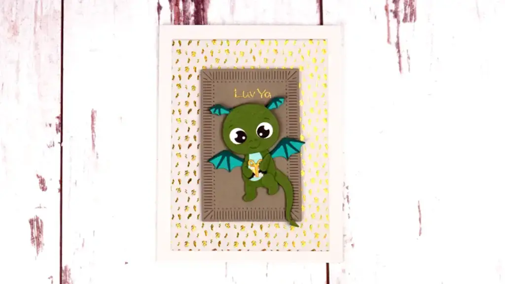 A green and gold dragon bookmark on a wooden background.