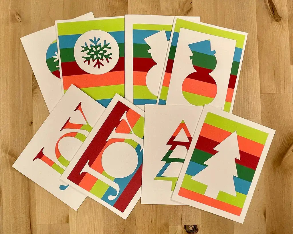 A set of coloring Christmas cards on a wooden table.