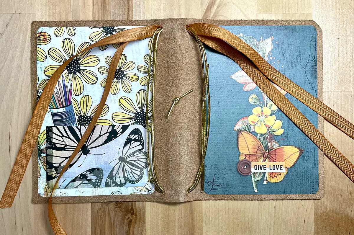 A Crafters leather journal with a butterfly and flowers on it, perfect for Traveler's Notebook enthusiasts.