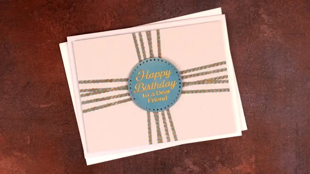A happy birthday card with a blue ribbon on it made with a press plate from the Pressed Posies Collection.