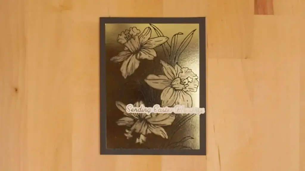 A black and gold card with burnished daffodils that make them stand out.