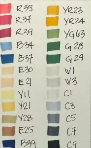 Watercolor swatches with different colors on a piece of paper.