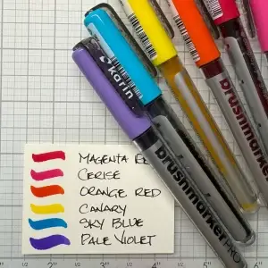 A group of pens with different colors on a piece of paper.