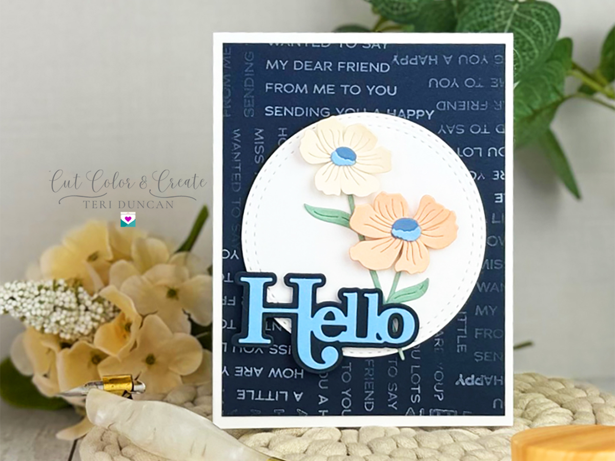 A Little Hello card in peaches in blue featuring die-cut flowers and the word Hello